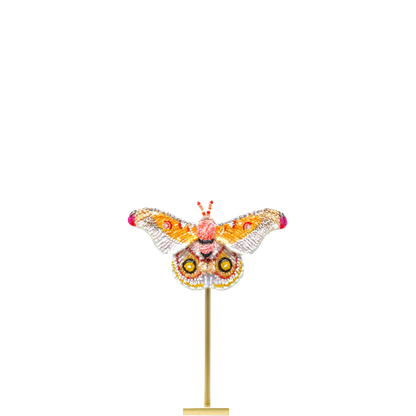 Decorative butterfly sculpture on a stand with a white background