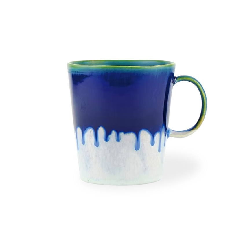 Blue and white ceramic mug with a green rim on a white background