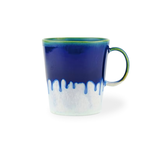 Blue and white ceramic mug with a green rim on a white background