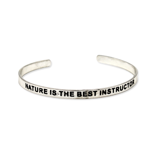 Silver cuff with the motto "Nature is the best instructor"