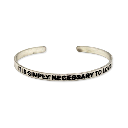 Silver cuff with the motto "It is simply necessary to love"