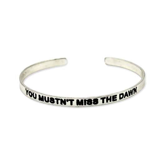 Silver cuff with the motto "You mustn't miss the dawn."