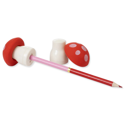 Red and white mushroom-shaped pencil sharpener with a pink pencil on a white background