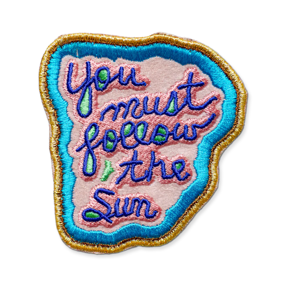 Embroidered patch with 'You must follow the sun' text on a white background