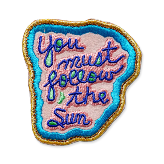 Embroidered patch with 'You must follow the sun' text on a white background