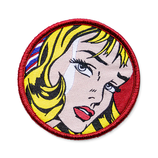 Circular patch with a stylized face design on a white background