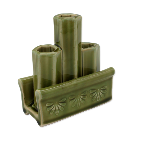 Green ceramic holder with three cylindrical slots on a white background