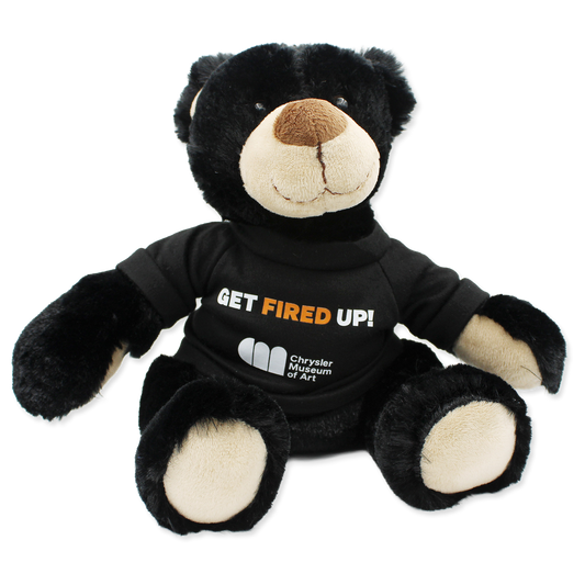 Black teddy bear wearing a shirt with text and a logo on a white background