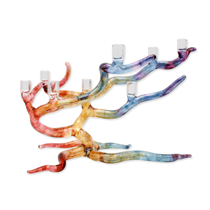 Colorful glass candle holder shaped like a windswept tree on a white background
