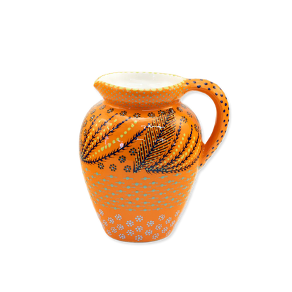 Decorative ceramic pitcher with orange and black patterns on a white background