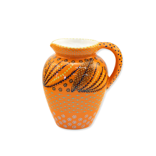 Decorative ceramic pitcher with orange and black patterns on a white background