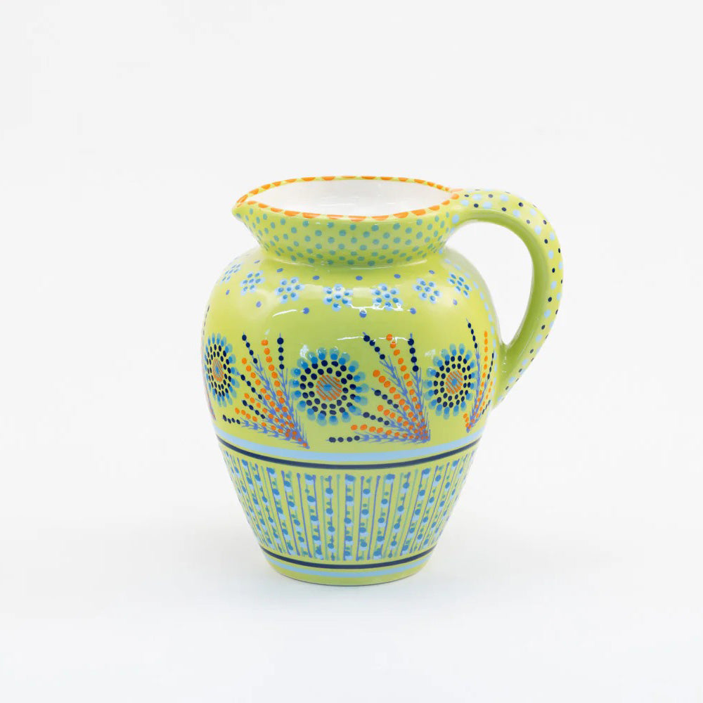 Decorative ceramic pitcher with floral patterns on a white background
