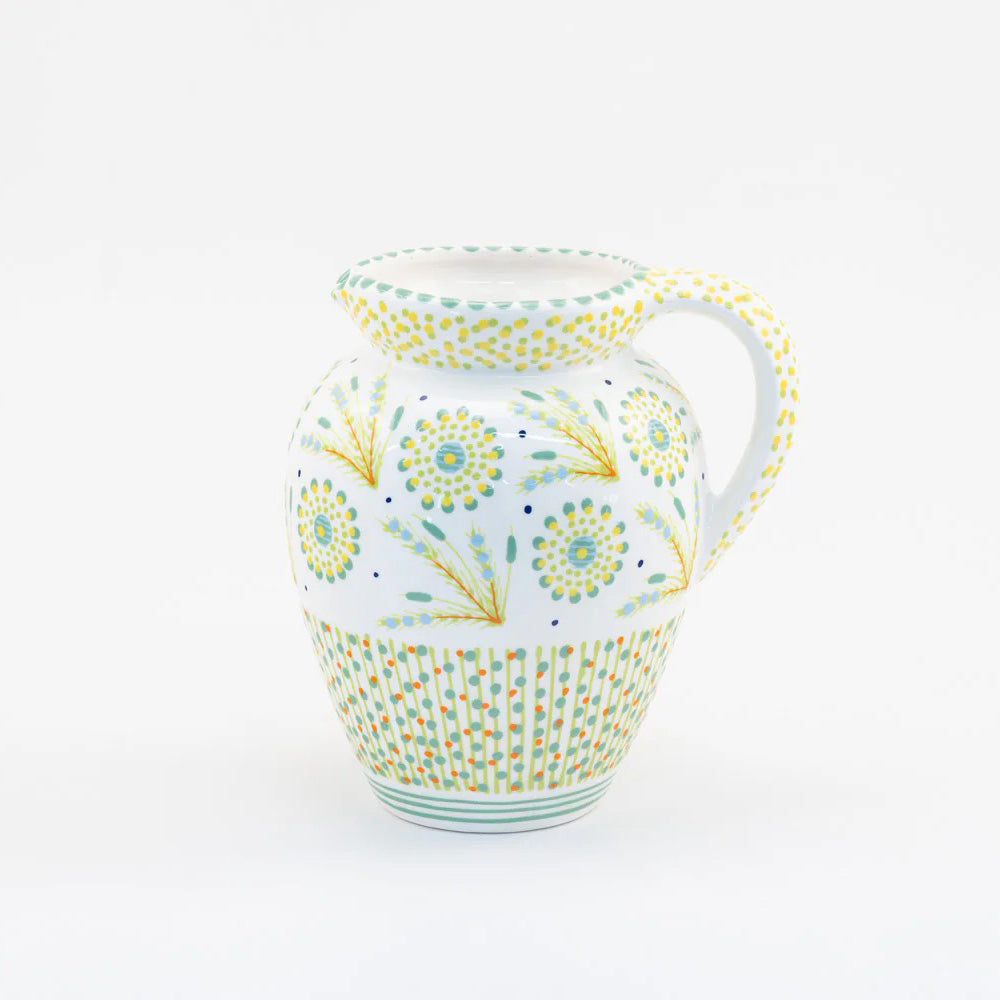 Decorative ceramic pitcher with floral patterns on a white background