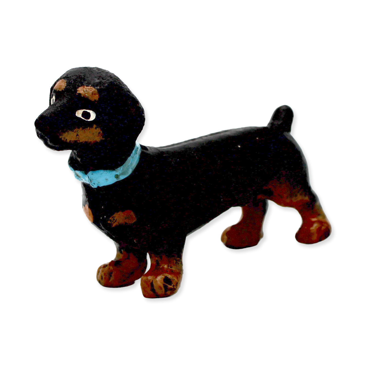 Black and brown dog figurine with a blue collar on a white background