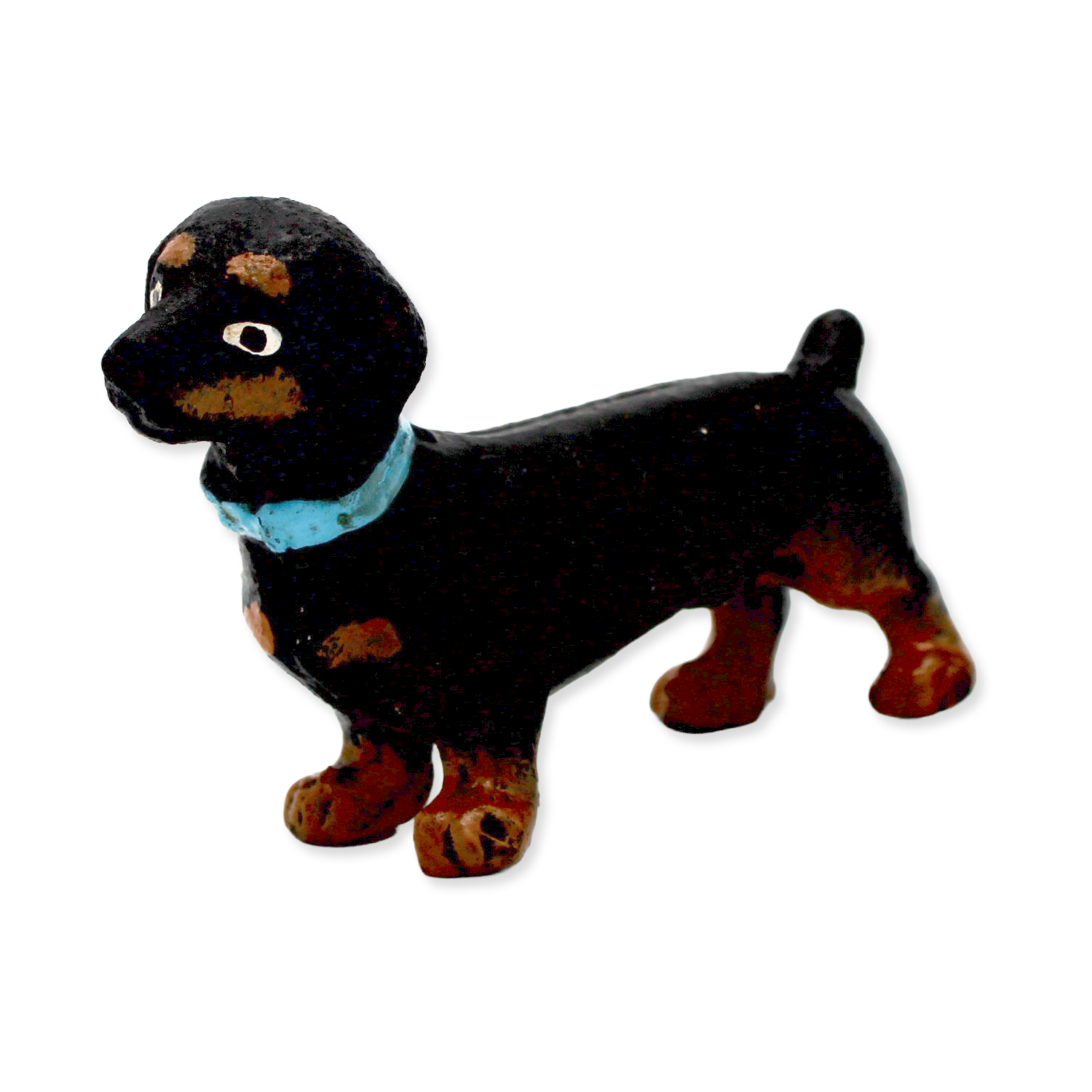 Black and brown dog figurine with a blue collar on a white background