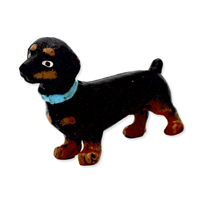 Black and brown dog figurine with a blue collar on a white background