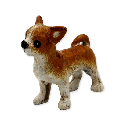 Small brown and white dog figurine on a white background