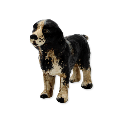 Vintage-style cast iron dog with black and brown coloring on a white background