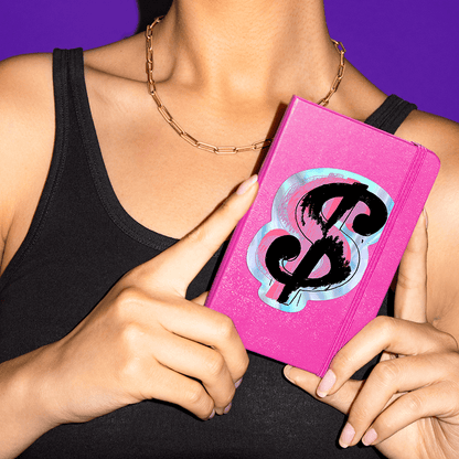 Woman holding a notebook featuring a sticker of Andy Warhol's $.