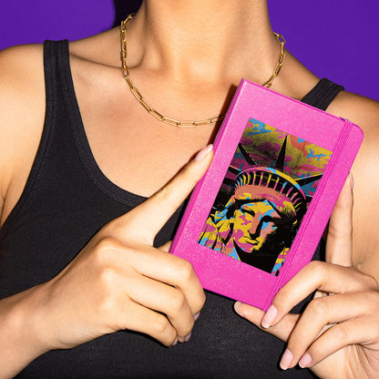 Woman holding a notebook, with a sticker of the stature of liberty on it.