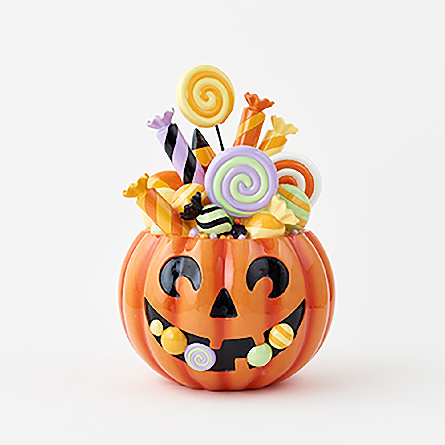 Halloween-themed candy display with smiling jack-o'-lantern face and colorful candies on a white background