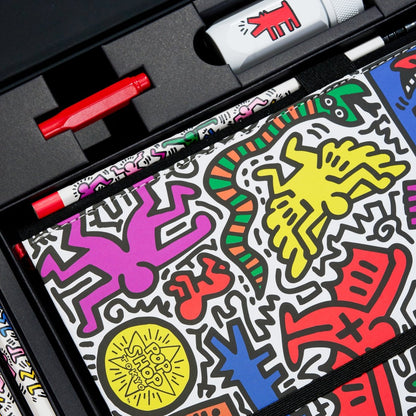 Colorful art supplies with Keith Haring-style designs in a black case.