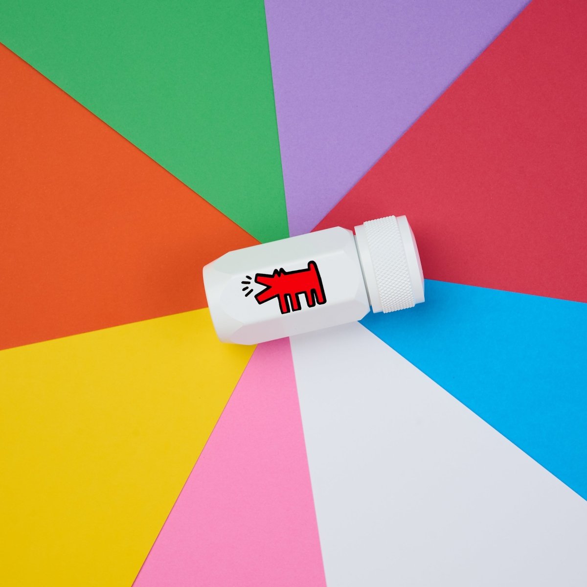 White pencil sharpener with a red logo on a colorful geometric background