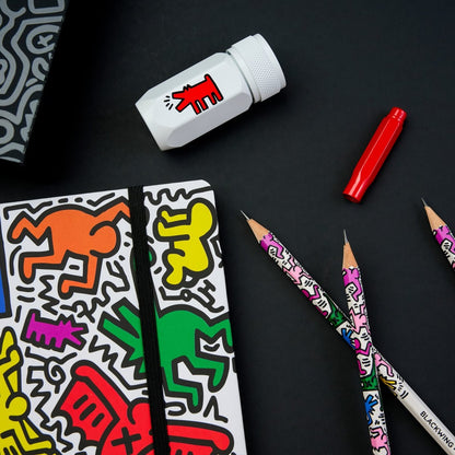 Colorful stationery items including a notebook, markers, and pencils on a black background