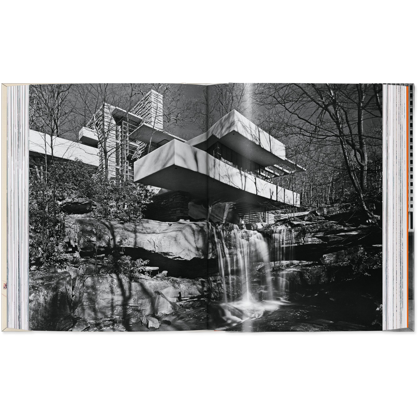 Open book showing a black and white photograph of a modern building integrated with nature.