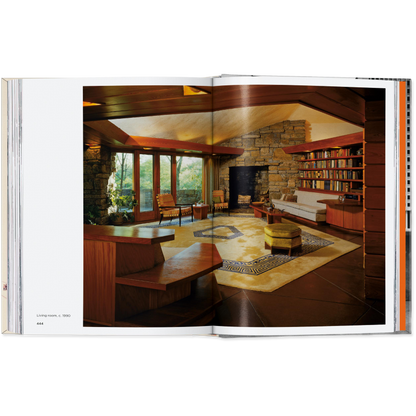 Open book showing a modern living room with a stone wall and bookshelf.
