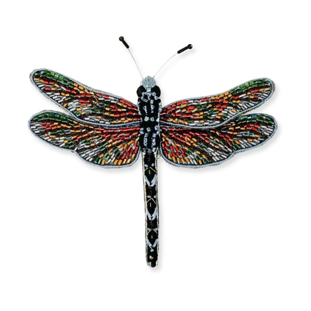 Colorful dragonfly-shaped brooch on a white background