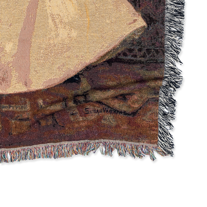 Close-up of a textured fabric with geometric patterns and fringes on a white background