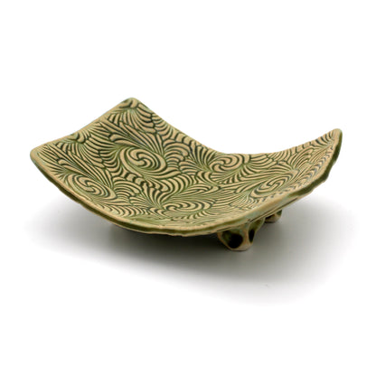Green ceramic dish with wavy pattern on a white background