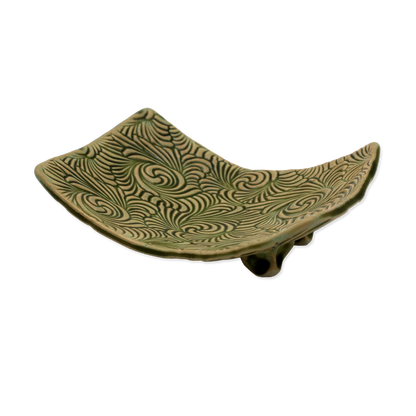 Green ceramic dish with wavy pattern on a white background