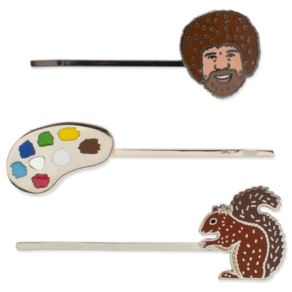Three hair pins with artistic designs on a white background