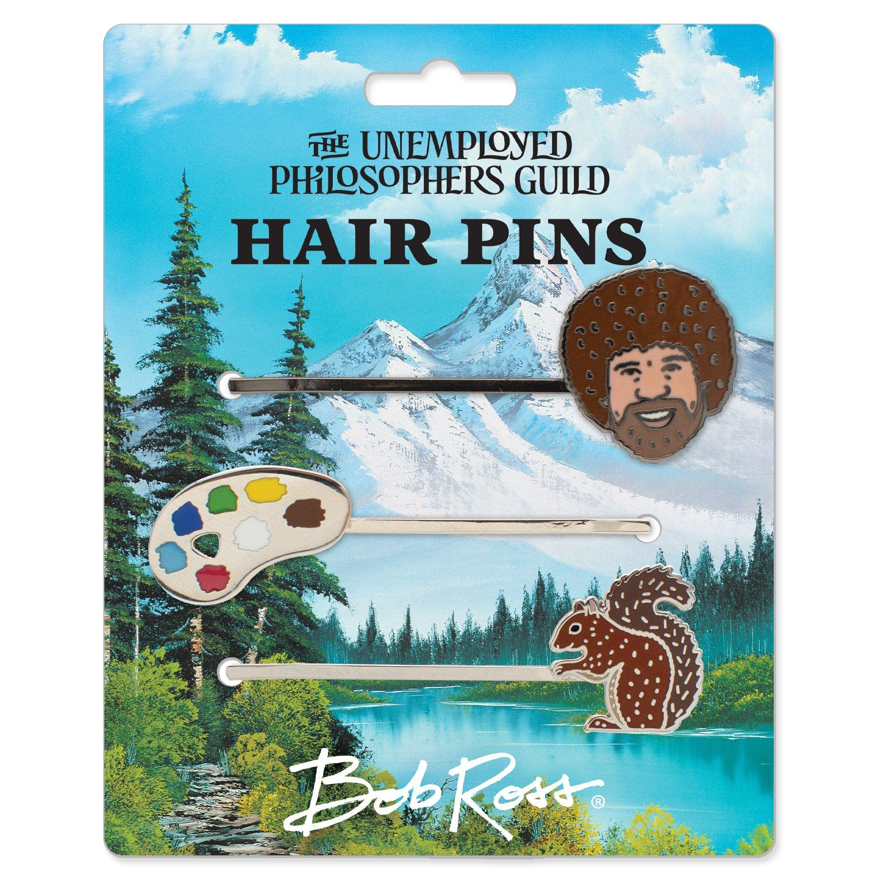 Packaged hair pins with nature-themed designs on a scenic background, featuring 'The Unemployed Philosophers Guild' and 'Bob Ross'.
