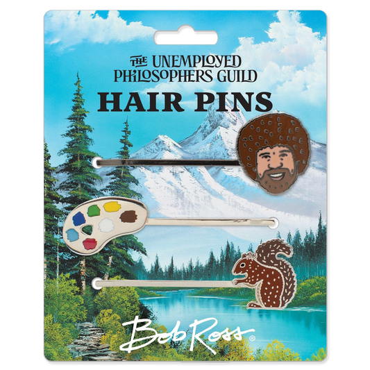 Packaged hair pins with nature-themed designs on a scenic background, featuring 'The Unemployed Philosophers Guild' and 'Bob Ross'.