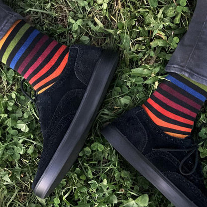 Black shoes with colorful striped socks on grass