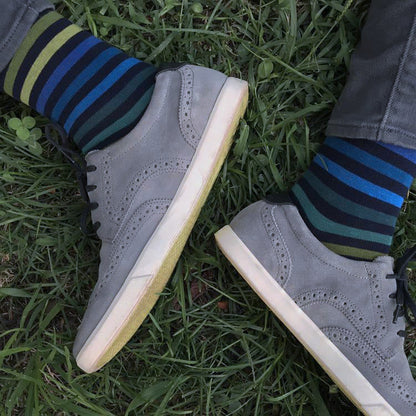 Gray sneakers with striped socks on grass