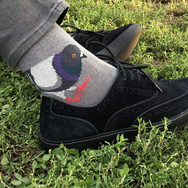 Black shoe with gray sock featuring a bird design on grass