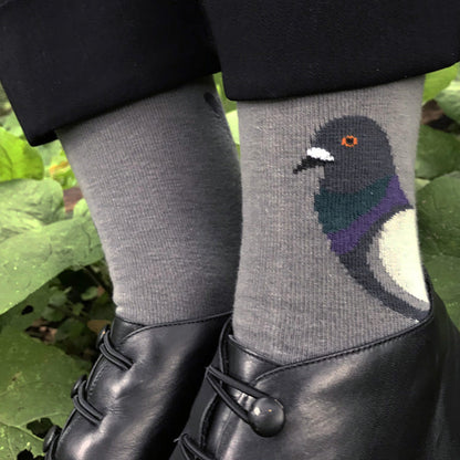 Gray socks with a pigeon design worn by a person in a natural setting.