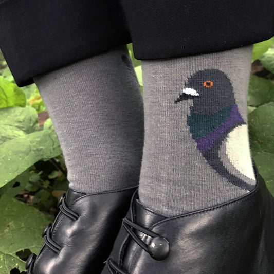 Gray socks with a pigeon design worn by a person in a natural setting.