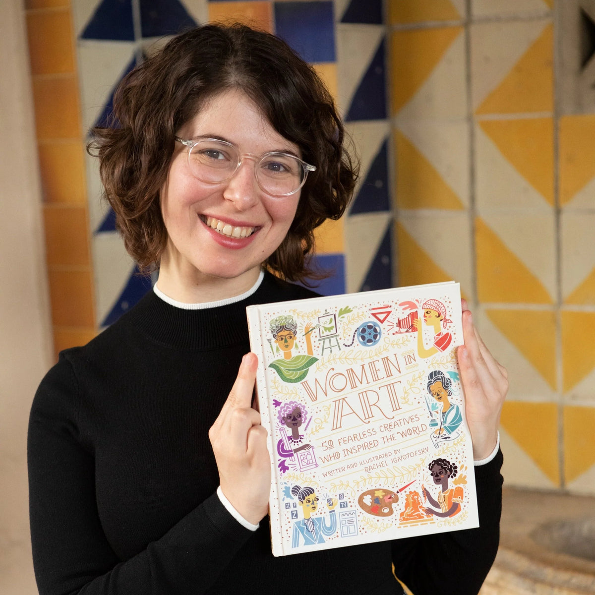 Rachel Ignotofsky, holding up a copy of her book, "Women in Art"
