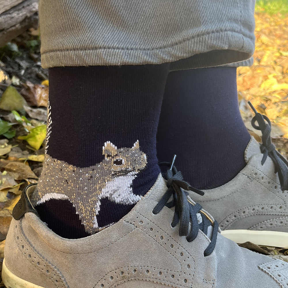 Navy socks with a squirrel design worn with beige shoes outdoors.