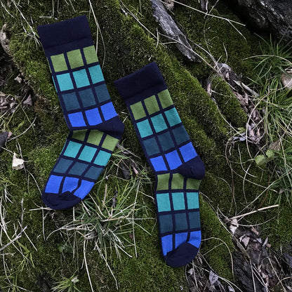 Pair of blue and green checkered socks on a grassy background
