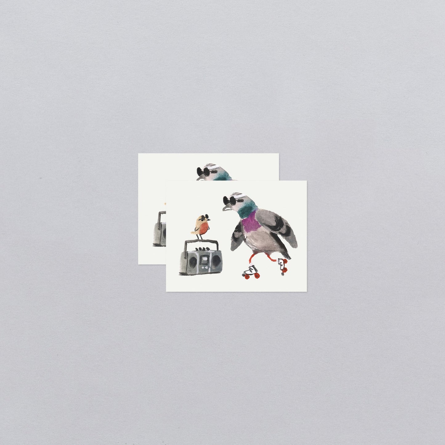 Two temporary tattoos with cartoon birds on a gray background
