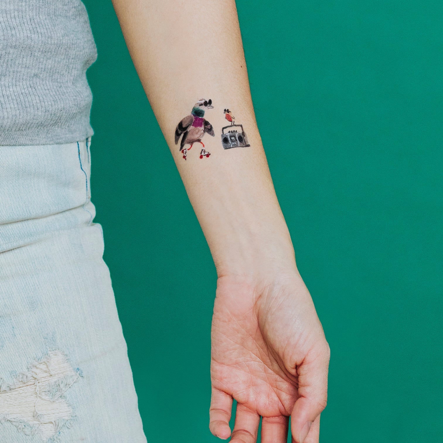 Person's arm with a tattoo on a green background